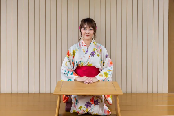 在日本风格的房子里穿着日本传统和服 有木制桌子的年轻女人 — 图库照片