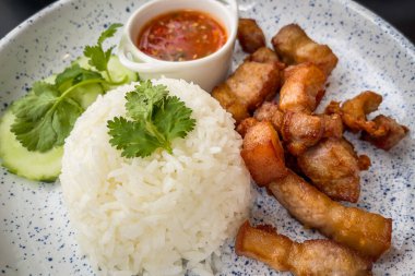 Sehpanın üzerinde balık soslu, kişniş salatalıklı ve biberli kızarmış domuz eti.