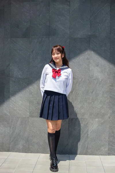 身穿日本校服的妇女站在一幢日式建筑前 — 图库照片