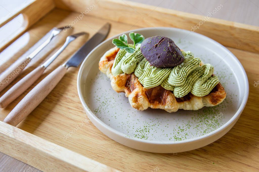 Closeup of Green tea waffles in a white plate with cutlery and cutlery