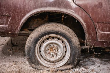 Üzerinde toz ve toprak olan eski bir arabanın sızdıran lastiği. Klasik araba.