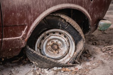 Üzerinde toz ve toprak olan eski bir arabanın lastikleri sızdırıyor. Klasik araba.