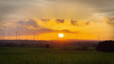 Rüzgar türbini gün batımında güzel gökyüzü ve bulutlarla rüzgar enerjisinden elektrik üretmek için.