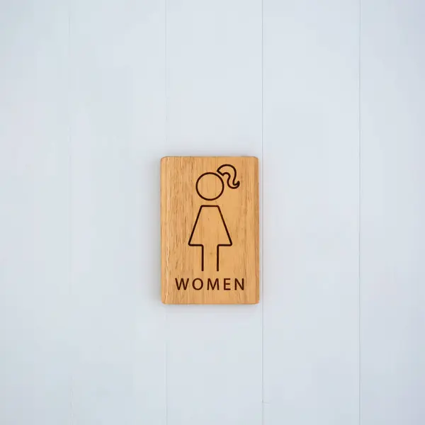 Female or woman toilet wood sign on the wall. copy space background