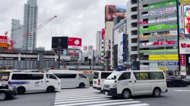 Tokyo, Japonya - 15 Kasım 2023: Shibuya Kavşağı 'nda hem yerli hem de turistlerin yanı sıra yoldaki trafikte birçok insan karşıya geçer. Tokyo 'da ünlü bir yerdir..