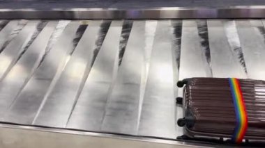 Havaalanında dönen taşıma bandındaki bavullar sahiplerini bekler..