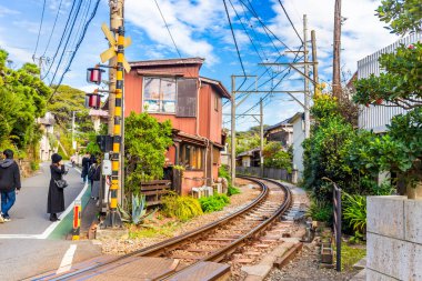 Kamakura 'nın tren raylarının yanındaki ünlü kafesi, otur, ayakta dur, yemek ye, iç ve trenlerin Japonya' ya yakın geçişini izle.