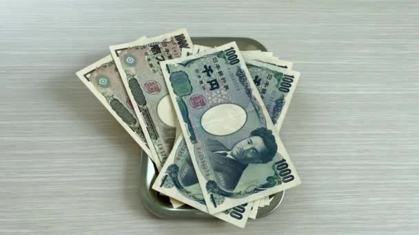 手数着日元 包括钞票和硬币 然后放在盘子里 准备用来购物 经商或旅行 — 图库视频影像