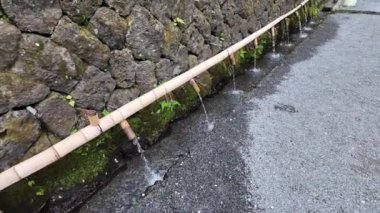 Geleneksel Japon bambu su boruları doğal ortama uyum sağlamak ve onu eşsiz ve güzel kılmak için yürüyüş yoluna kurulur..