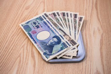 Japon 1,000 ve 10,000 yenlik banknotlar iş ve satın alma için değişim tepsilerine konur..