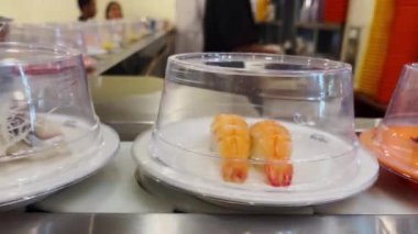 Dönen taşıma bandında birçok çeşit suşi vardır..