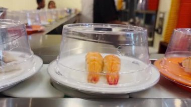 Dönen taşıma bandında birçok çeşit suşi vardır..