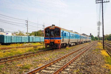 Dizel tren, arka planda birçok ray, trafik ışığı ve yük vagonu bulunan Tayland 'da hızlı bir şehirlerarası trendir..