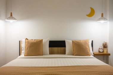 Beyaz, şirin bir yatak odası. Geceleri lamba ve ahşap..