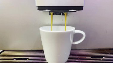 Modern bir otomatik kahve makinesi sıcak espresso yumrukluyor. Köpük ve buhar çıkıyor..