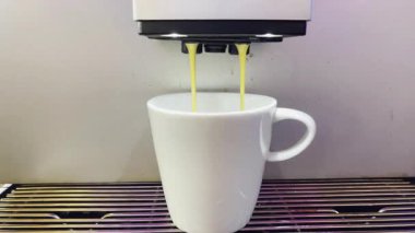 Modern bir otomatik kahve makinesi sıcak espresso yumrukluyor. Köpük ve buhar çıkıyor..