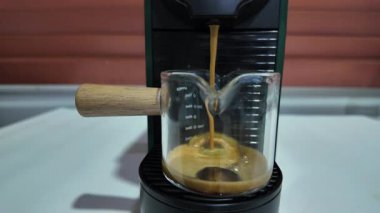 Modern bir otomatik kahve makinesi sıcak espresso yumrukluyor. Köpük ve buhar çıkıyor. Yavaş çekim 
