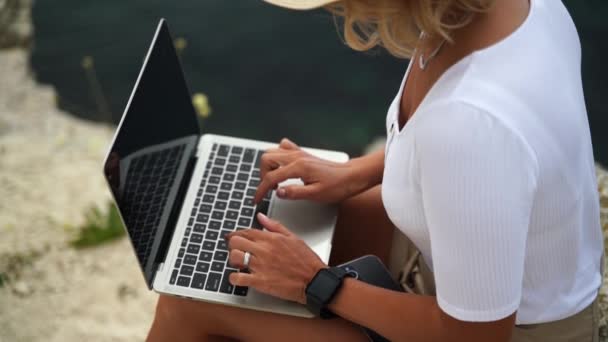フリーランスは コンピュータに手を書く女性の手を閉じます 美しい海の景色と屋外のラップトップのキーボードにタイピング中年の女性をよく見る — ストック動画