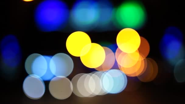 ボケの車は夜の街で点灯する 夜間のヘッドライトと街灯を遮断しました 夜に車のボケのサークルを移動する 輝かしい都市交通の背景 — ストック動画