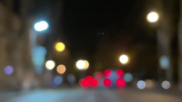 夜の街でブレイクされた車のライトボケ 夜間のヘッドライトと街灯を遮断しました 夜に車のボケのサークルを移動する 輝かしい都市交通の背景 — ストック動画