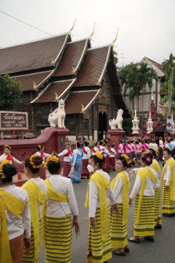 CHIANG MAI THAILAND - 16 Mayıs 2023: Inthakin Festivali veya Sai Khan Dok geleneği Chiang Mai 'nin Chiang Mai, Tayland' daki Wat Chedi Luang 'daki sütununa çiçek sunan vatandaşlardır..