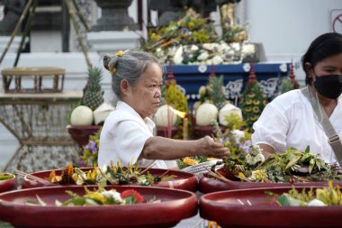 CHIANG MAI THAILAND - 16 Mayıs 2023: Inthakin Festivali veya Sai Khan Dok geleneği Chiang Mai 'nin Chiang Mai, Tayland' daki Wat Chedi Luang 'daki sütununa çiçek sunan vatandaşlardır..