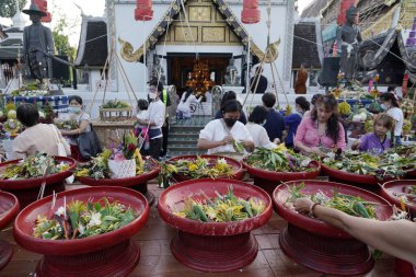 CHIANG MAI THAILAND - 16 Mayıs 2023: Inthakin Festivali veya Sai Khan Dok geleneği Chiang Mai 'nin Chiang Mai, Tayland' daki Wat Chedi Luang 'daki sütununa çiçek sunan vatandaşlardır..