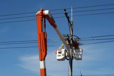 CHIANG MAI, THAILAND 14 Kasım 2023: Elektrik işçisi yüksek voltajlı elektrik kablolarını tamir etti.