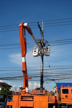 CHIANG MAI, THAILAND 14 Kasım 2023: Elektrik işçisi yüksek voltajlı elektrik kablolarını tamir etti.