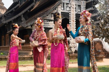 Bir grup güzel Lanna Asyalı kadın Tayland kostümü giyip Songkran festivalinde birbirlerine su sıçratarak eğleniyorlar.. 