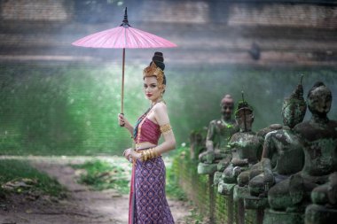 Tayland 'ın Chiang Mai şehrinde eski bir tapınakta geleneksel Tayland Dvaravati elbisesi giymiş güzel genç bir ASEAN kadını.. 
