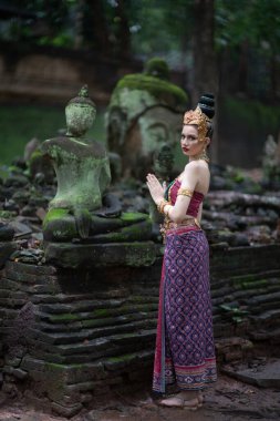 Tayland 'ın Chiang Mai şehrinde eski bir tapınakta geleneksel Tayland Dvaravati elbisesi giymiş güzel genç bir ASEAN kadını.. 