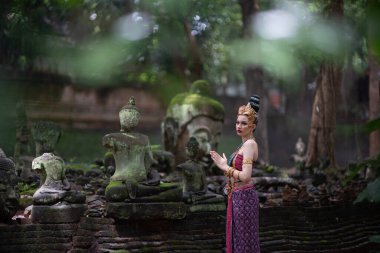 Tayland 'ın Chiang Mai şehrinde eski bir tapınakta geleneksel Tayland Dvaravati elbisesi giymiş güzel genç bir ASEAN kadını.. 