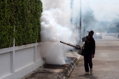 CHIANG MAI, THAILAND - 24 HAZİRAN 2022: Yetkililer konut inşaatındaki sivrisinekleri önlemek için ilaç sıkıyorlar.