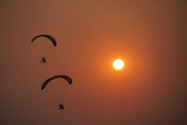 Doğada günbatımına sahip paramotor.