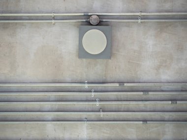 The installation of a electric wire system in steel pipes for the building on cement wall.