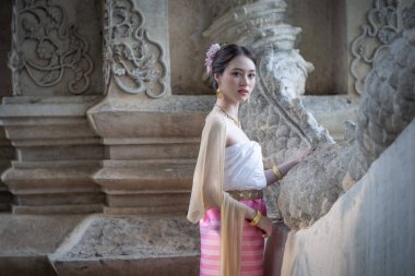 Tayland 'ın Chiang Mai şehrinde eski bir tapınakta geleneksel Tayland Dvaravati elbisesi giymiş güzel genç bir ASEAN kadını.. 