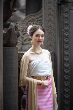 Tayland 'ın Chiang Mai şehrinde eski bir tapınakta geleneksel Tayland Dvaravati elbisesi giymiş güzel genç bir ASEAN kadını.. 