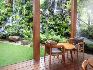 Doğanın ortasında şelaleli bir kafe dekorasyonu.