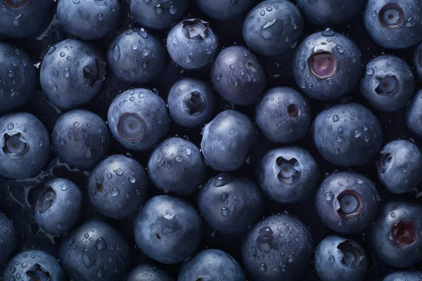 A lot of small Fresh Blueberries seamless background, adorned with some glistening droplets of water.