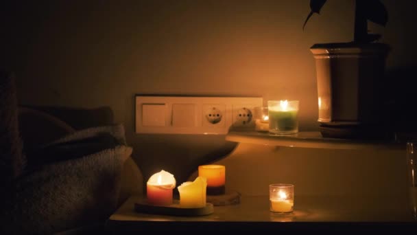 暗い部屋にろうそく テーブルとソケットの上でろうそくを燃やす 家の中に電気はない 街の停電だ エネルギー危機の概念 — ストック動画