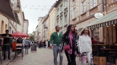 Old city crowdy street. European old town. Ukrainian city Lviv with street cafes and ancient buildings