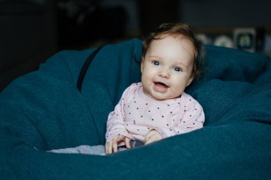 Küçük kız fasulye çuvalında oturuyor. Oyuncak oynayan tatlı bebek. Bebek odasında 6 aylık bebek..