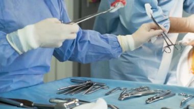 Ameliyat için hazırlıklar. Ameliyat aletleri. Ameliyat odasındaki masada birden fazla ameliyat aleti var. Hemşire ellerini lastik eldivenlerle fırçala. Modern tıbbi konsept.