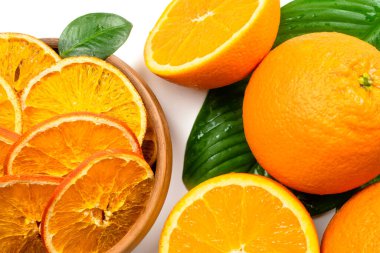 Kuru portakal dilimleri ve beyaz arka planda taze meyveler. Kurutulmuş portakal meyveleri. Sağlıklı, şekersiz tatlı yemek. Şekerli narenciye.