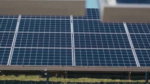 太陽光発電の太陽光発電パネル ソーラーパークで 緑の草と青い空のソーラーパネル ソーラーパネルシステム発電機 オルタナティブパワーエネルギーコンセプト — ストック動画