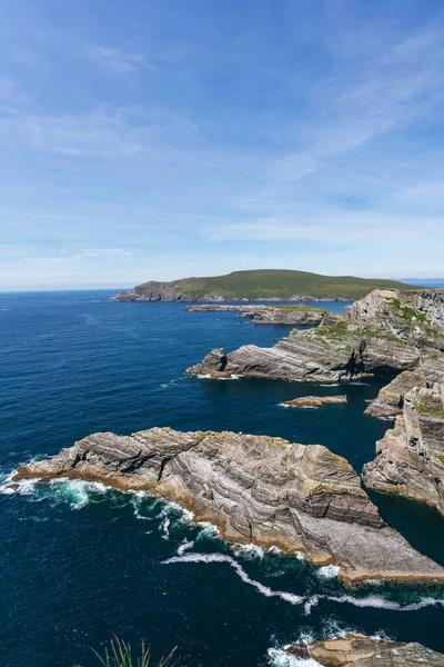 Ireland 'ın dikey uçurumlarının nefes kesici güzelliğini yakalayın, çarpıcı bir ışıkla yıkanmış, canlı bir mavi gökyüzü ve ışıl ışıl deniz manzarasına karşı..