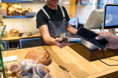 Çabasız fırın deneyimi: Müşteri kasanın yanındaki ekmek ve kekler için telefonla ödeme yapıyor.
