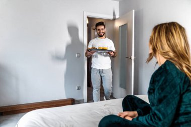 Genç bir çiftin kocası, onu yatakta bekleyen karısı için hazırladığı kahvaltıyı getiriyor. Koca, karısı için bir sürpriz hazırlar. Romantik kahvaltı. Yurt içi yaşam tarzı.