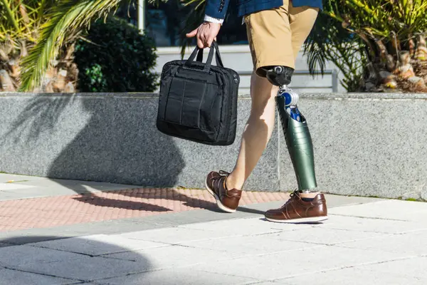 stock image Corporate professional with orthopedic leg going to work, illustrating diversity and inclusion.